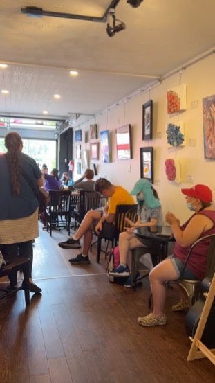 A group of people are sitting at tables in a restaurant.