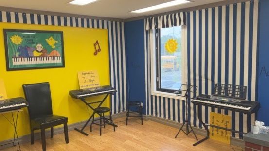 A room with a lot of keyboards and chairs in it