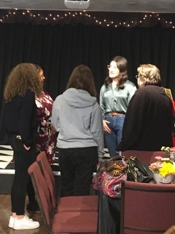 A group of people standing around a table in a room