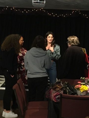 A group of people are standing around a table in a dark room