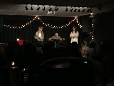 A group of people are standing on a stage in a dark room
