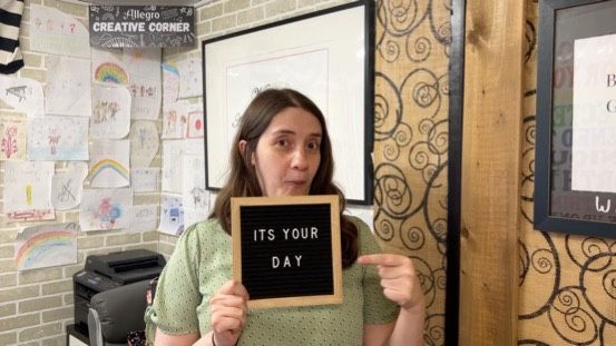 A woman is holding a sign that says `` it 's your day ''.