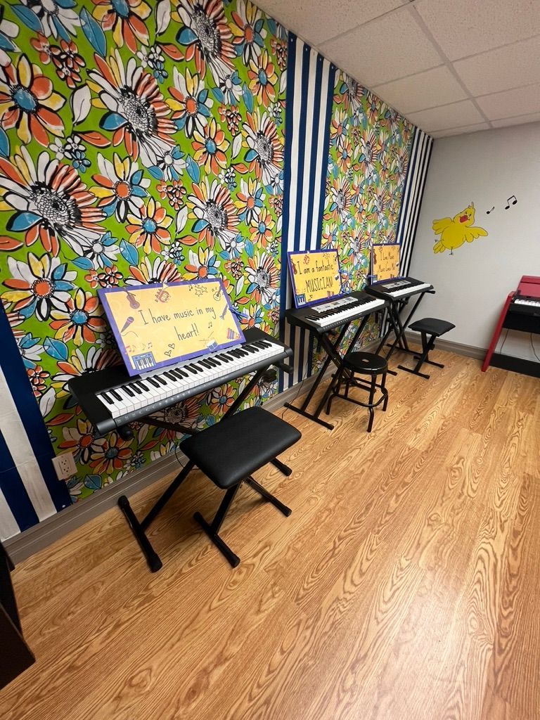 A room with a lot of keyboards and a wooden floor.