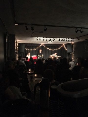 A group of people are sitting in a dark room watching a concert