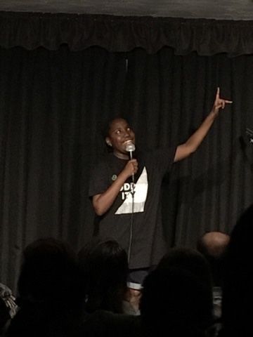A man wearing a shirt that says i 'm a dog is giving a speech in front of a crowd