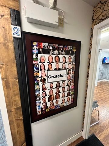 A framed picture of a group of people is hanging on a wall.