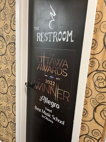 A black door with a sign on it that says `` the restroom ''.