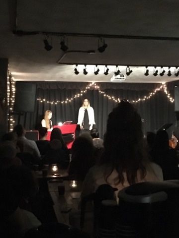 A woman stands on a stage in front of a crowd