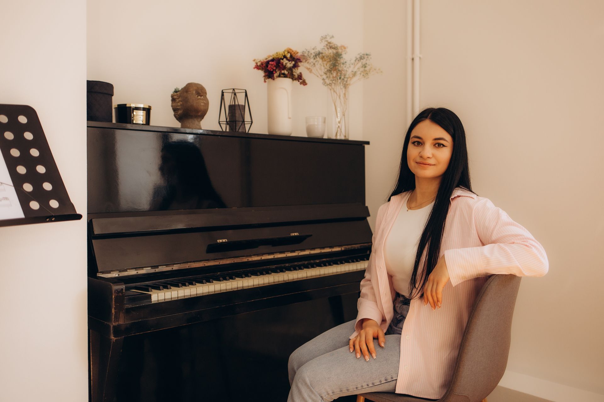 A woman is sitting in a chair in front of a piano.