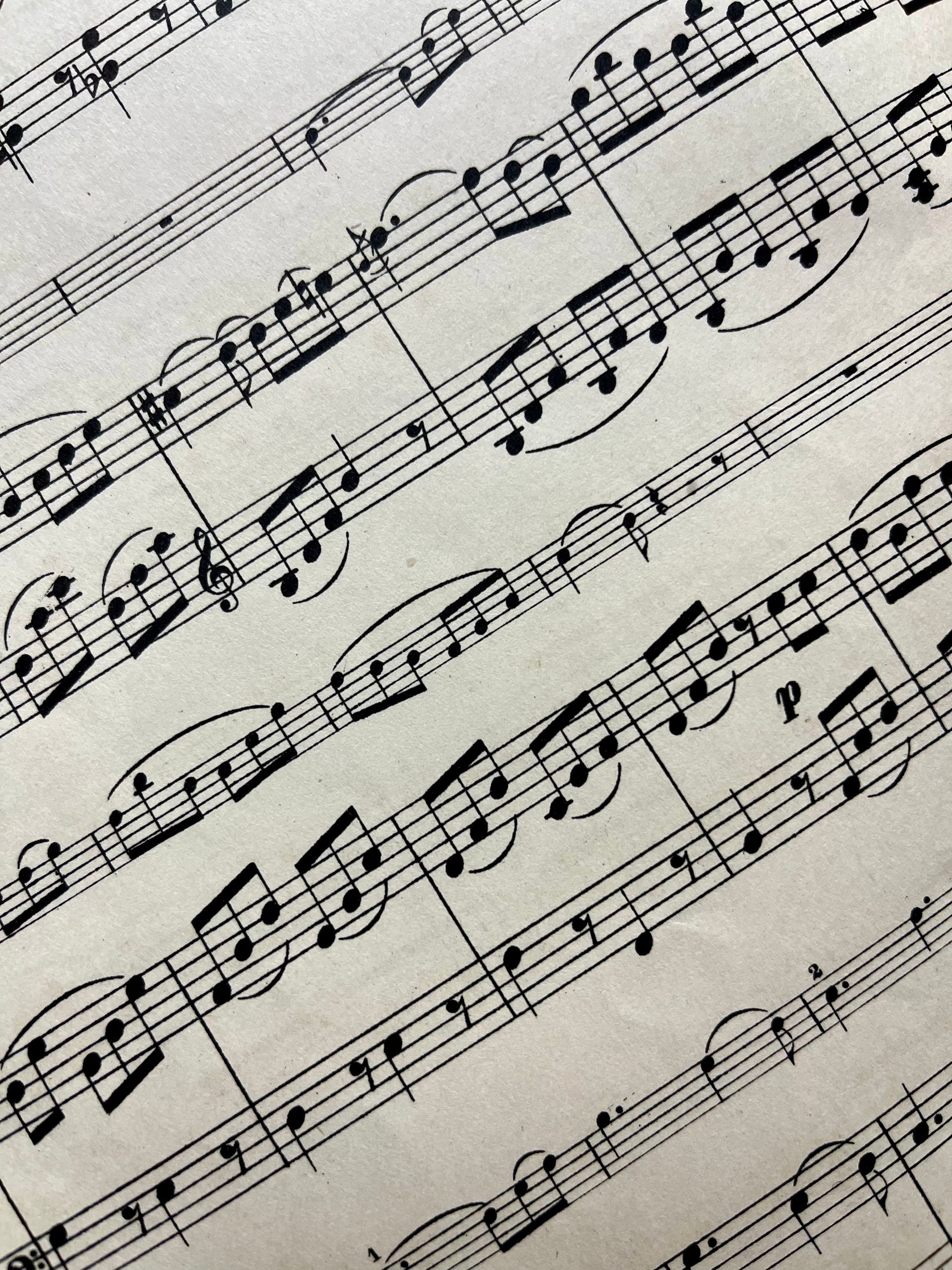 Musical score sheet, black notes on white paper, angled lines, notes and symbols.