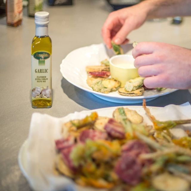 Chef che versa olio aromatizzato Aromolio su un piatto