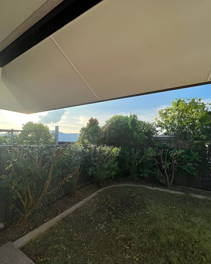 Backyard View With Shrubs, a Lawn, and a Partial Awning, With a Glimpse of a Mountain — Green Scene NT in Darwin, NT