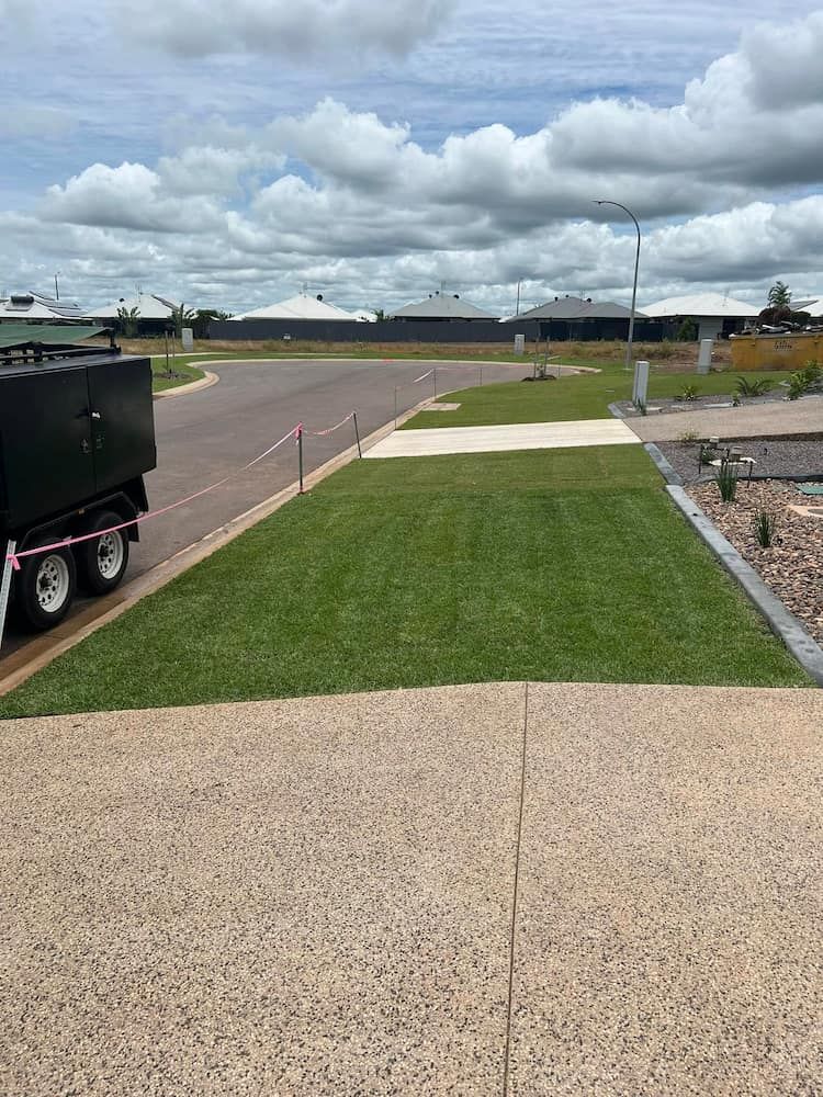 Green Lawn With Recently Cut Grass, Bordered by Tan Concrete and a Trailer on the Left — Green Scene NT in Darwin, NT