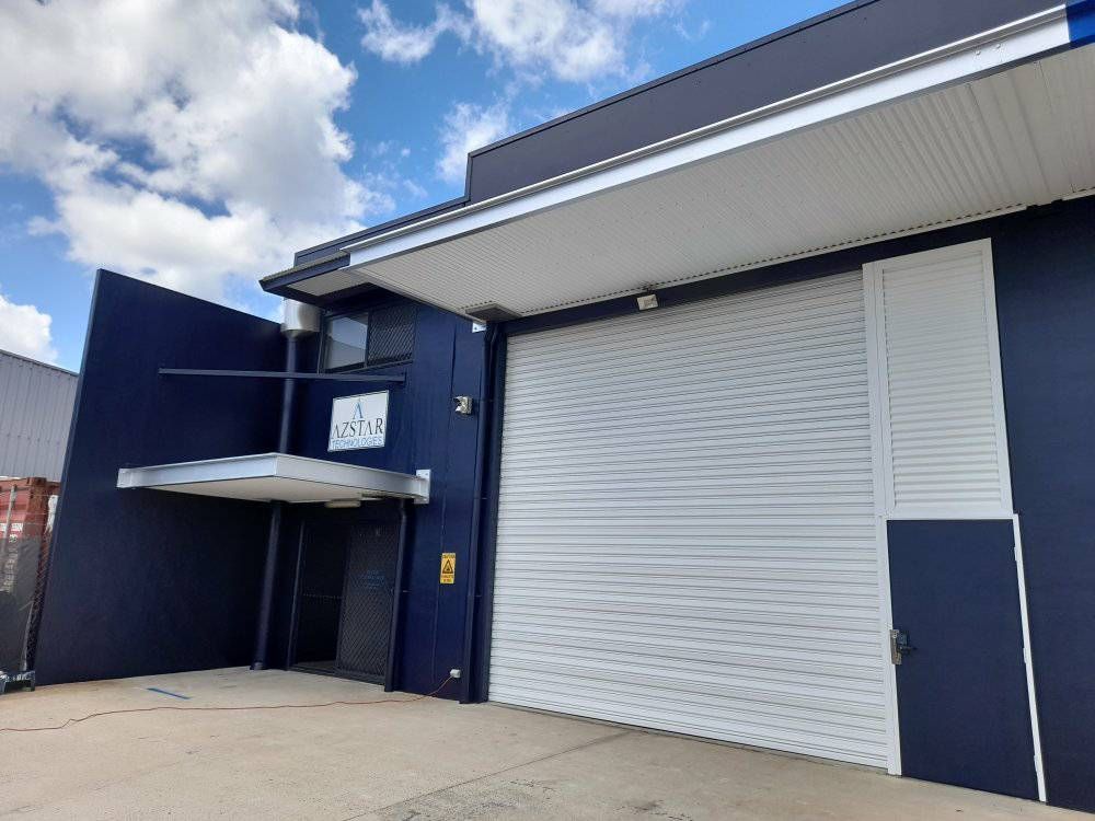 A Blue Building With A White Garage Door And A Blue Sky In The Background — Kiwi Painter In Mooroobool, QLD