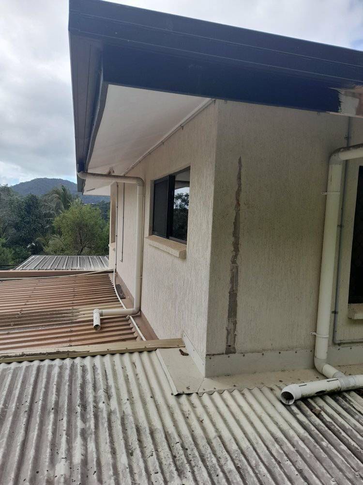 A White Building With A Corrugated Metal Roof And A Window — Kiwi Painter In Mooroobool, QLD