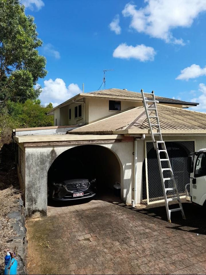 A Car Is Parked In A Garage Under A House With A Ladder On The Roof — Kiwi Painter In Mooroobool, QLD