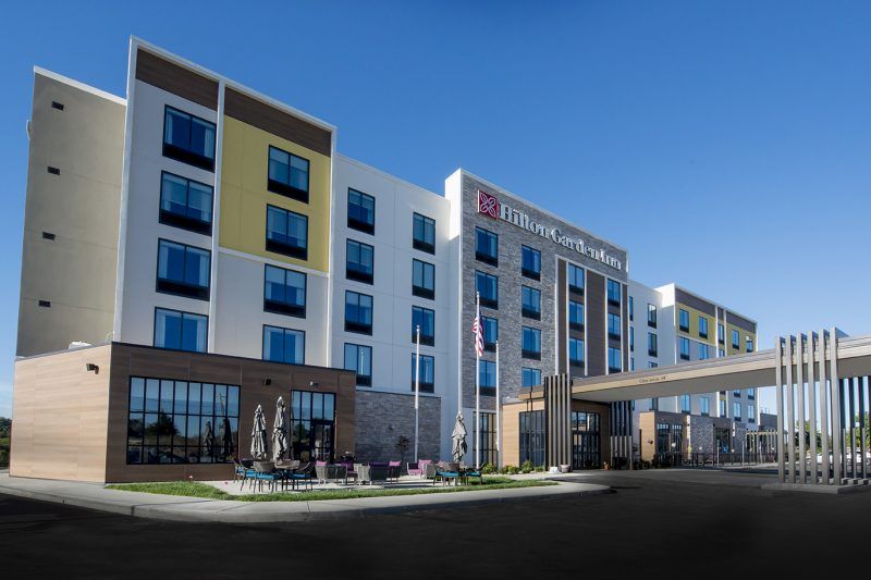 A large hotel with a lot of windows and a bridge.