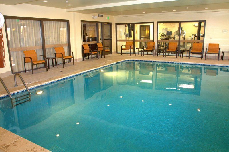 A large indoor swimming pool with chairs and tables around it