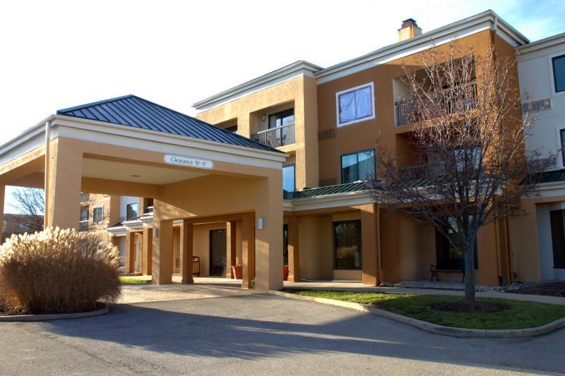 A large building with a lot of windows and a tree in front of it