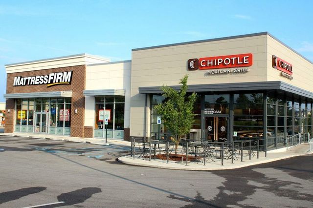 A chipotle restaurant is located next to a mattress firm store.