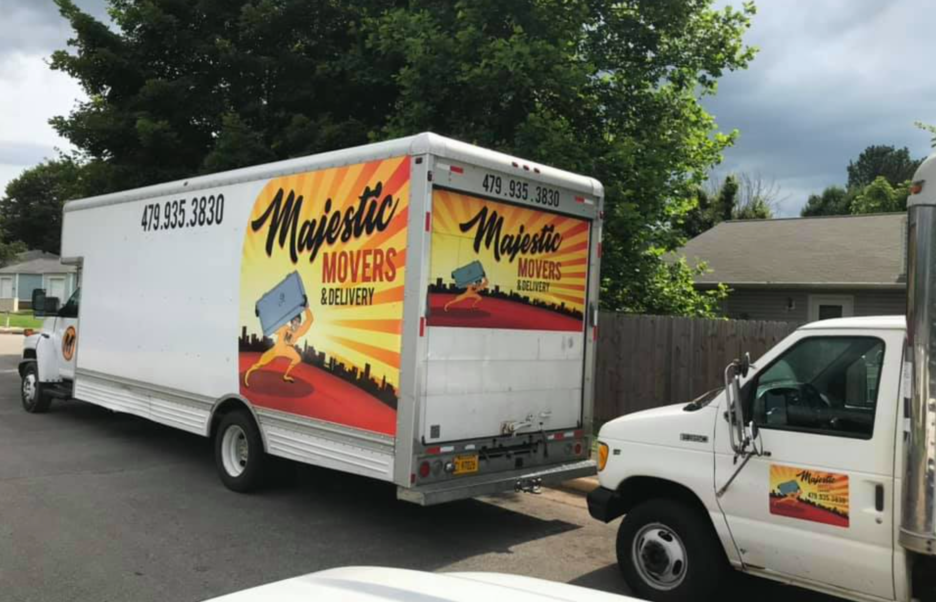 Two moving trucks are parked on the side of the road.