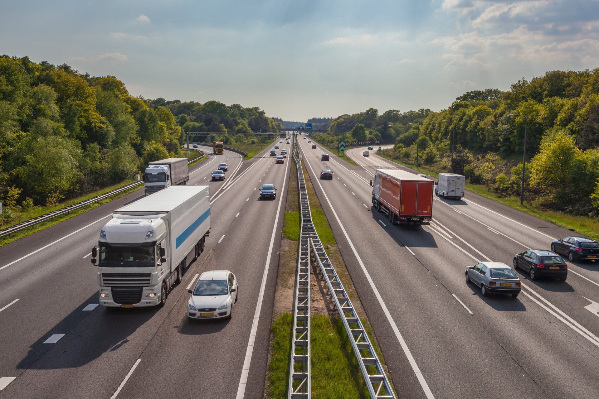 A highway filled with cars and trucks on a sunny day.