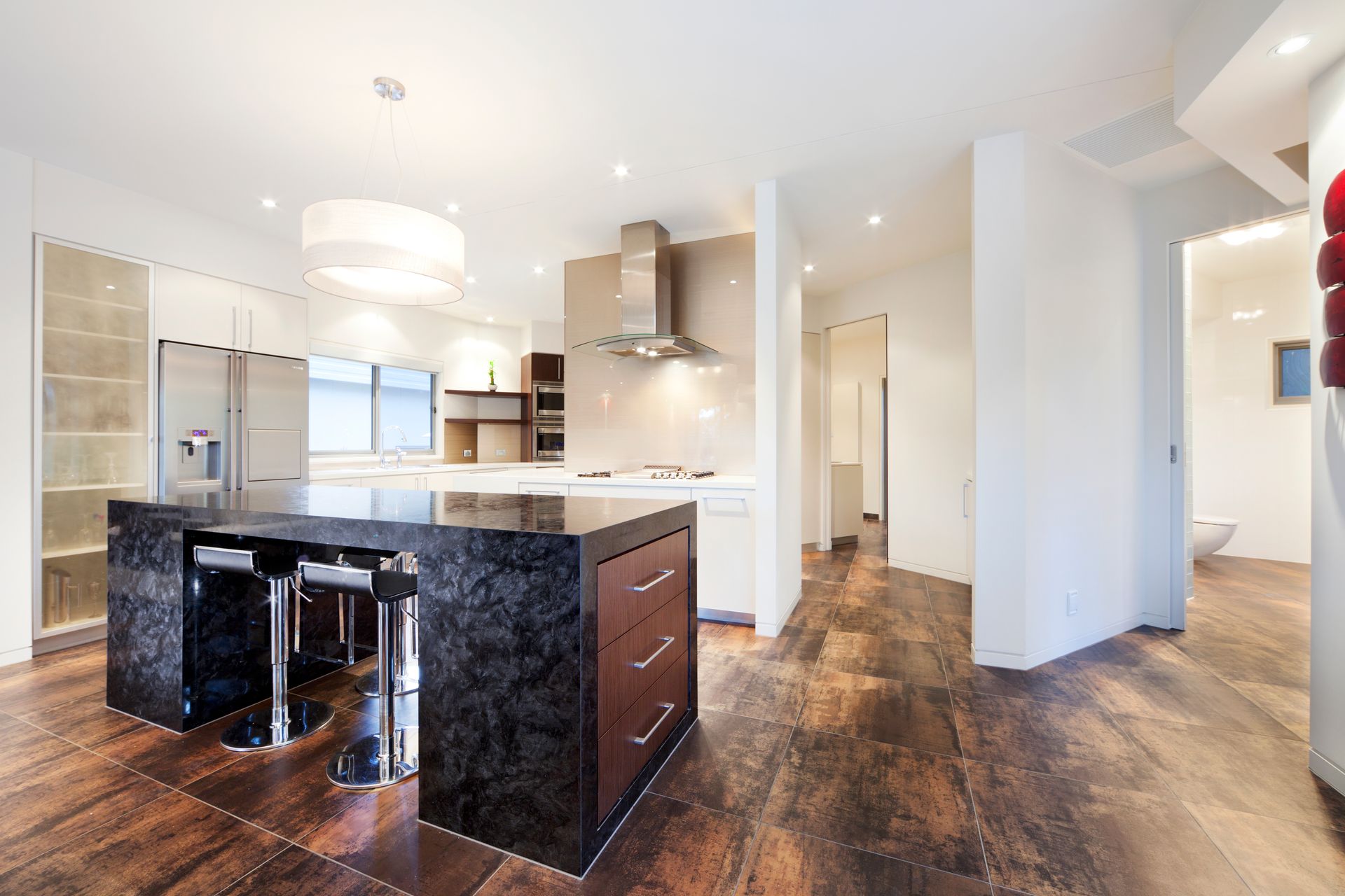 Modern Kitchen With Dark Granite Island, Stainless Steel Appliances — Rectified Edge Tiling & Bathroom Renovations in Jamison Centre, ACT