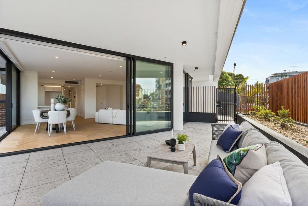 An outdoor area with a couch and open doors leading into a living room — Commercial Painting Group in Kembla Grange, NSW