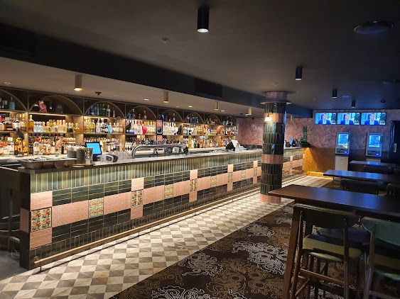 A Long Bar in a Restaurant With Tables and Chairs — Commercial Painting Group in Nowra, NSW