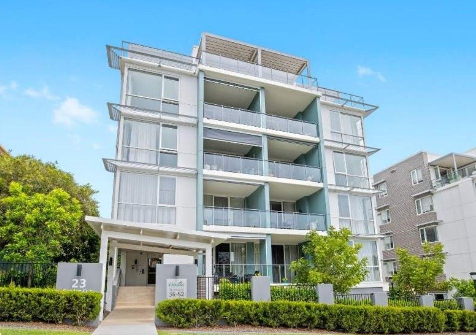 An apartment building with trees and bushes in front — Commercial Painting Group in Illawarra, NSW