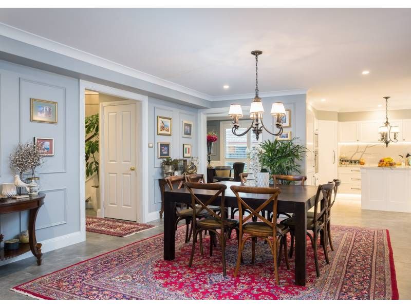 A Dining Room With a Table and Chairs and a Rug — Commercial Painting Group in Southern Highlands, NSW