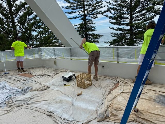 Three men are painting a balcony — Commercial Painting Group in Southern Highlands, NSW