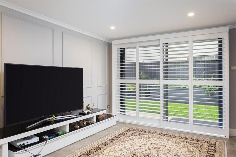 A room with a tv and windows — Commercial Painting Group in Thirroul, NSW