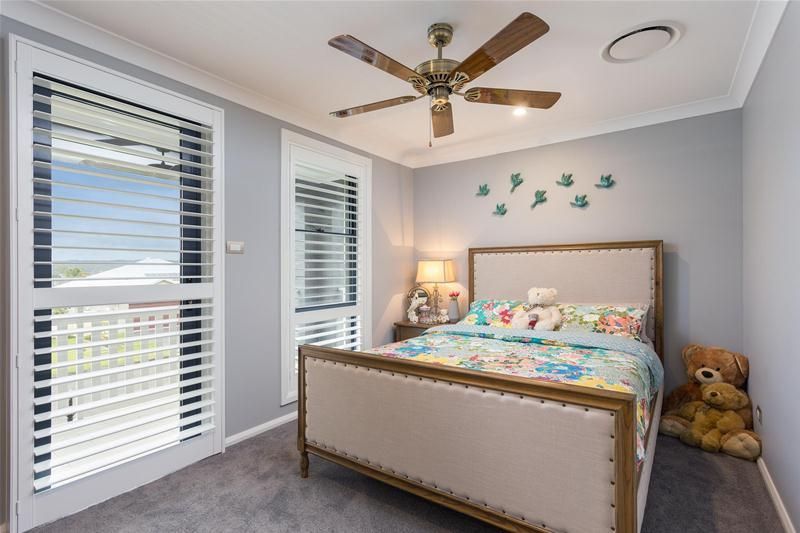 A childs bedroom with a bed and ceiling fan — Commercial Painting Group in Goulburn, NSW