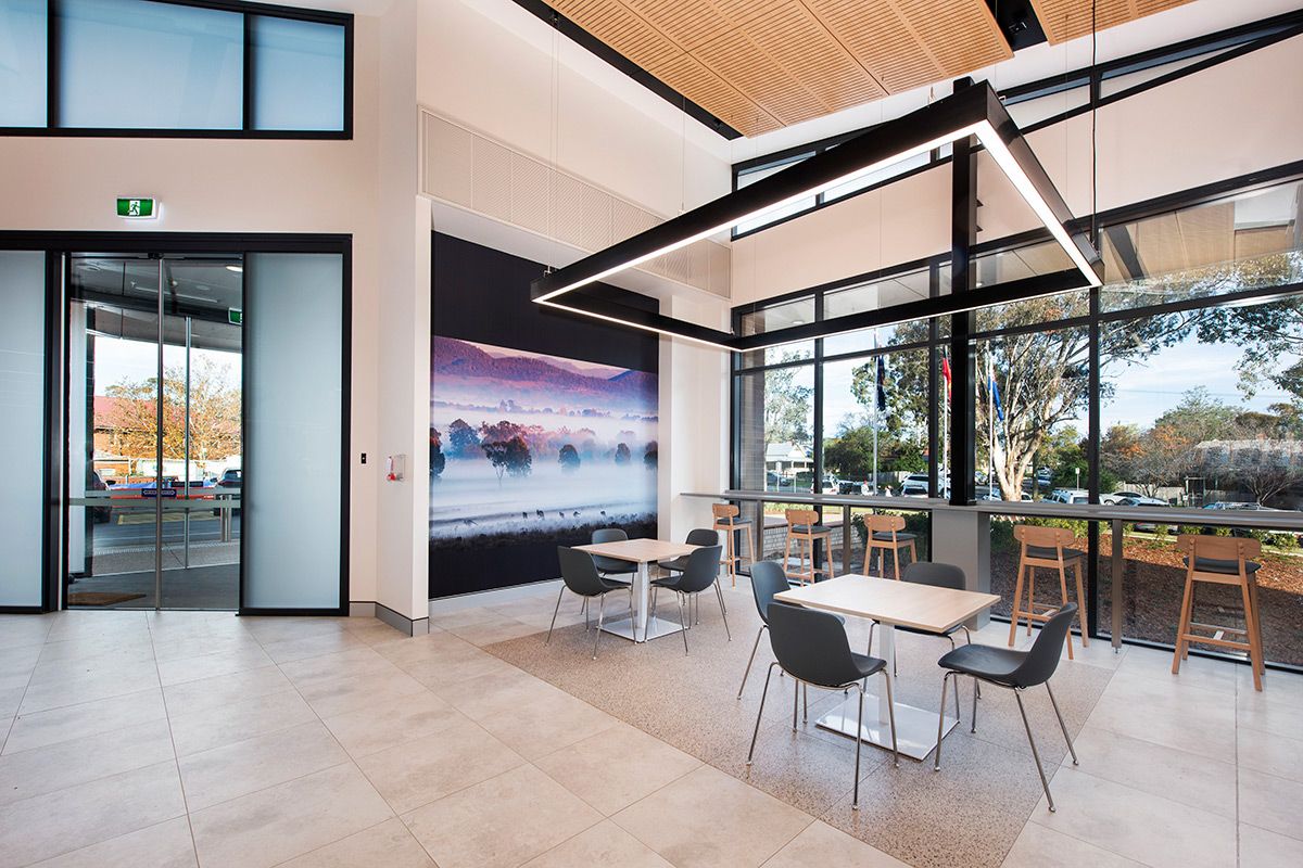 A room with large windows, tables and chairs and a door — Commercial Painting Group in Central West, NSW