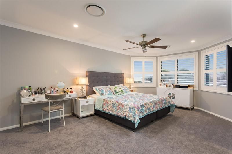 A large bedroom with grey carpets, a bed and a desk — Commercial Painting Group in Kiama, NSW