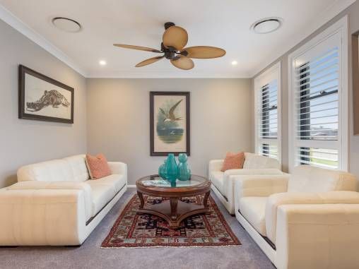 A sitting room with white couches and a small table — Commercial Painting Group in Shellharbour, NSW