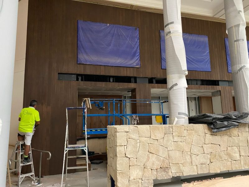 A man is working on a ladder — Commercial Painting Group in Canberra, ACT