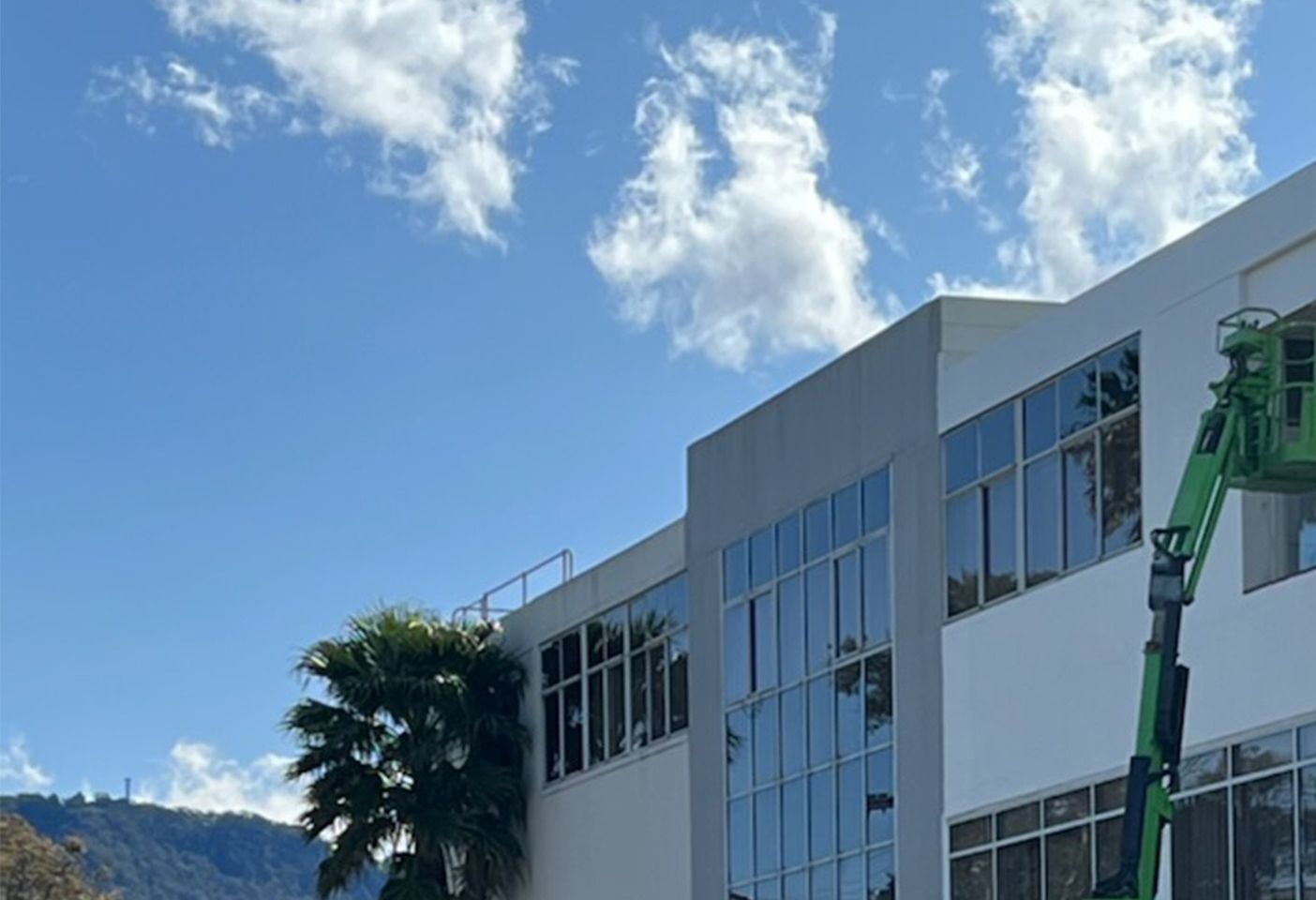 A Large Building with lots of windows and a green crane — Commercial Painting Group in Illawarra, NSW