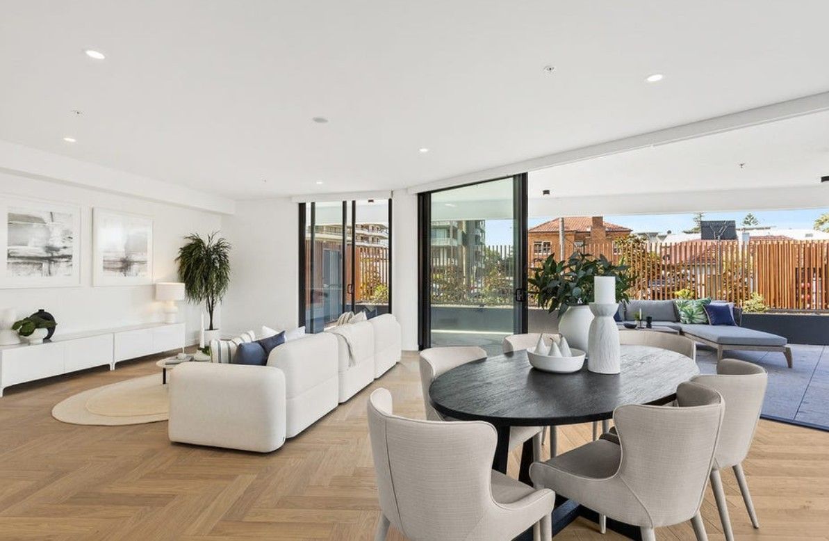 A living room with a white couch and a table and chairs — Commercial Painting Group in Kembla Grange, NSW
