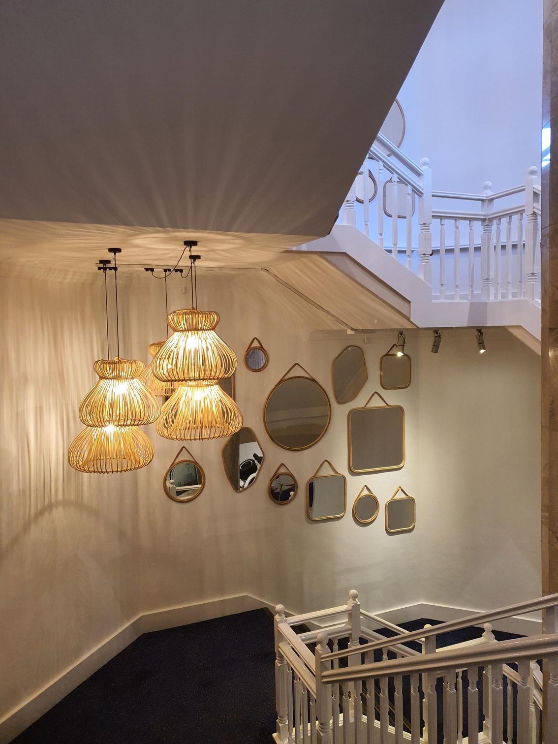 A staircase with hanging lights and mirrors on the wall — Commercial Painting Group in Kembla Grange, NSW