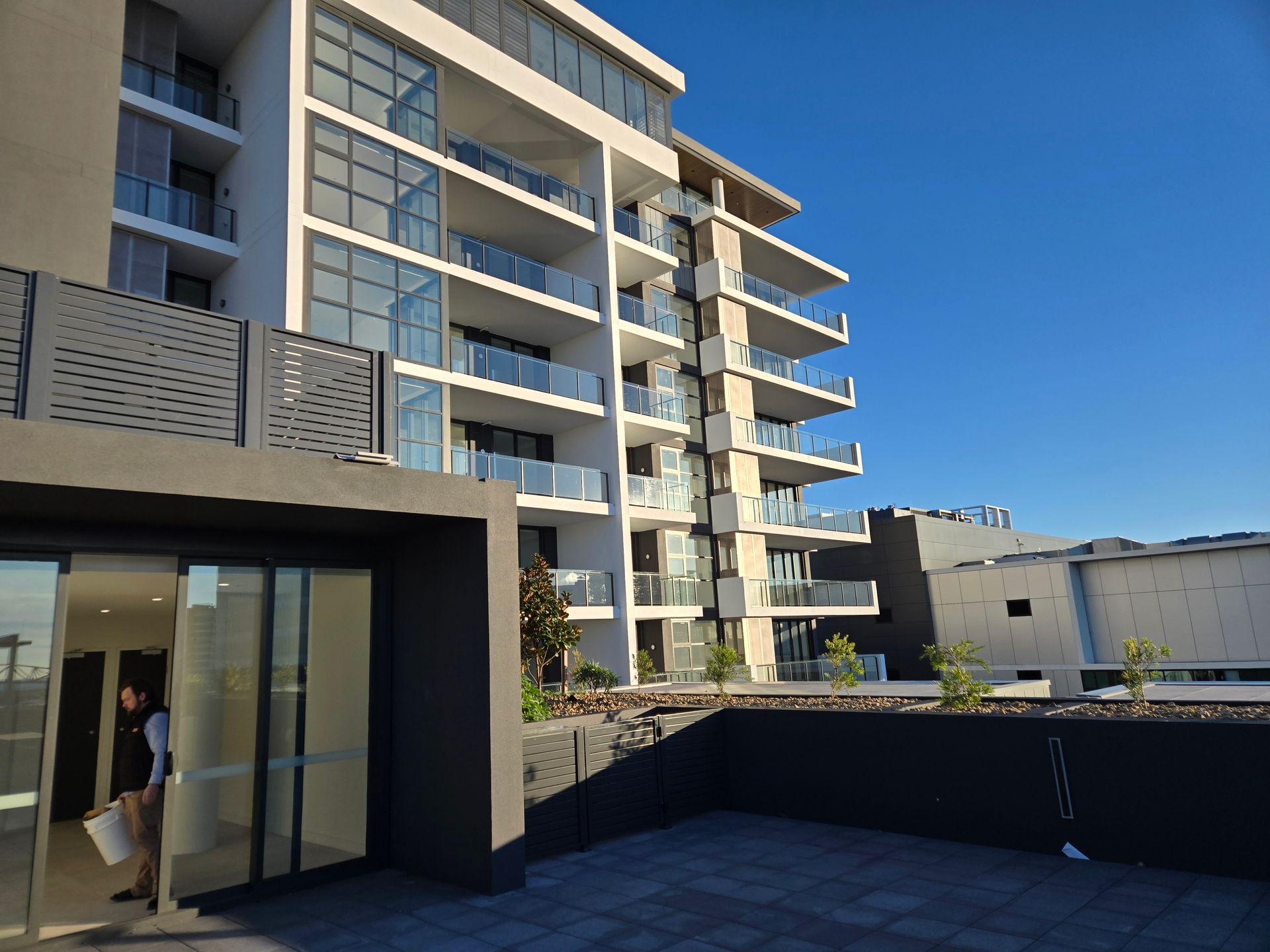 An apartment building with lots of balconies and glass fences — Commercial Painting Group in Kembla Grange, NSW
