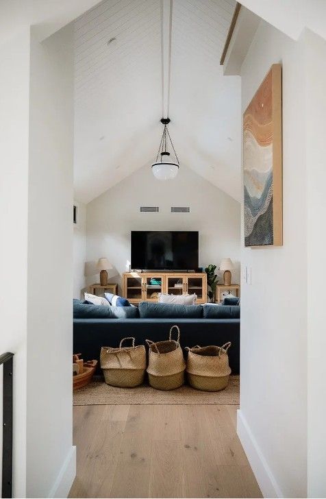 A living room with a blue couch, a TV and a painting on the wall — Commercial Painting Group in Kembla Grange, NSW