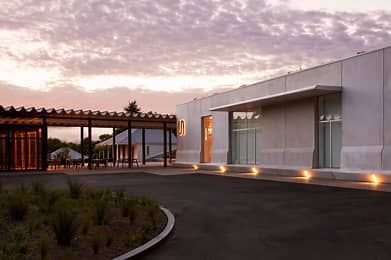 A concrete building with a road in front of it and a cloudy sky — Commercial Painting Group in Kembla Grange, NSW