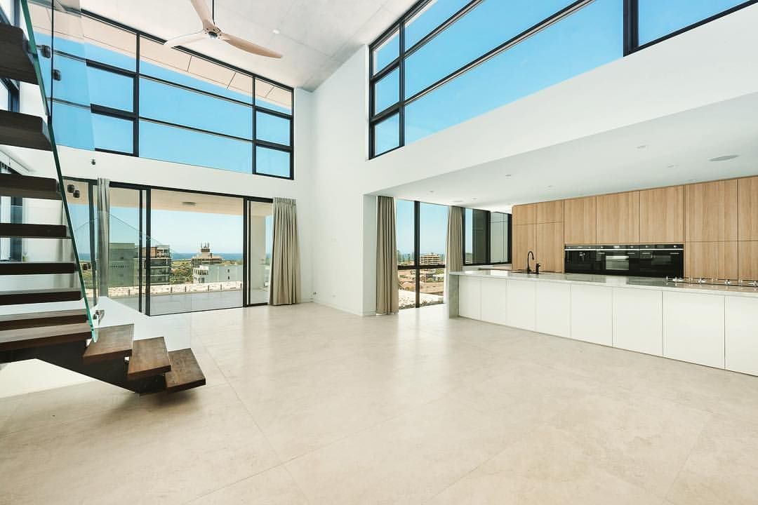 The inside of a large house with a kitchen and big windows — Commercial Painting Group in Kembla Grange, NSW