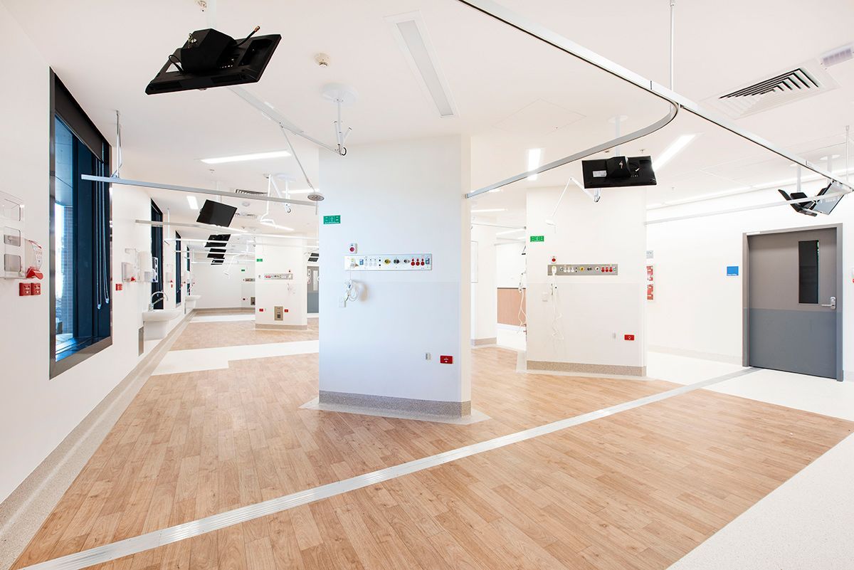 A hospital with white walls and televisions hanging from the ceiling — Commercial Painting Group in Kembla Grange, NSW