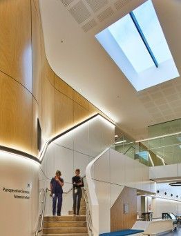 A hospital with two people walking down a staircase — Commercial Painting Group in Kembla Grange, NSW