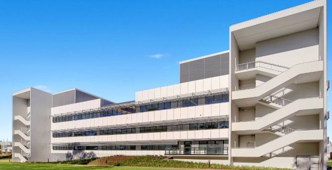 The outside of a hospital building with lots of windows and white walls — Commercial Painting Group in Kembla Grange, NSW