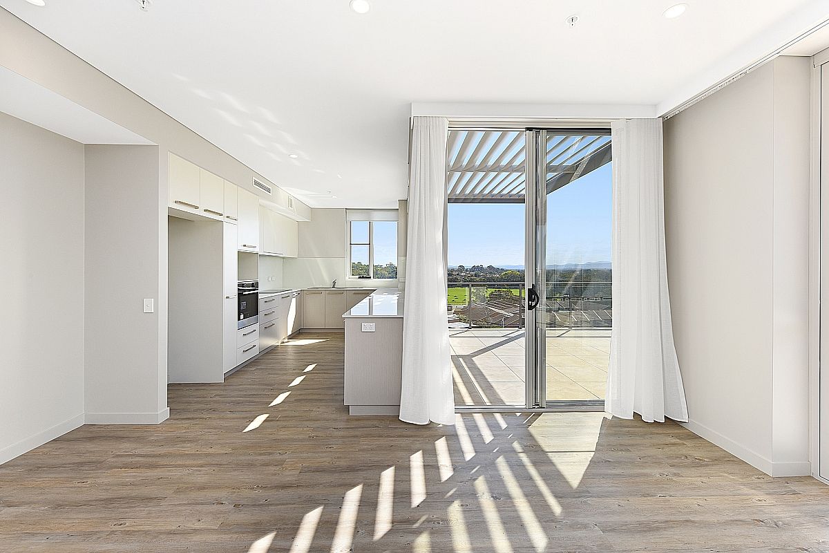 The inside of a house with a kitchen, a door leading outside and white curtains — Commercial Painting Group in Kembla Grange, NSW