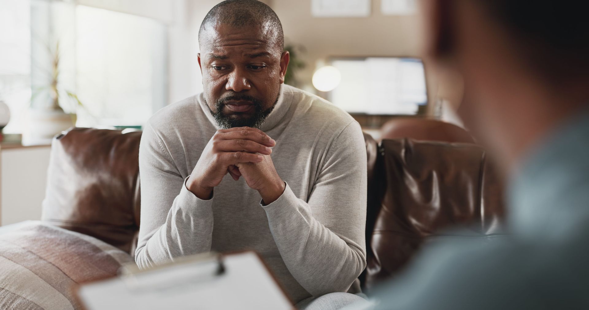Man sitting across from a therapist in a calm office setting, in Ridgewood NJ at Minisink Psychology